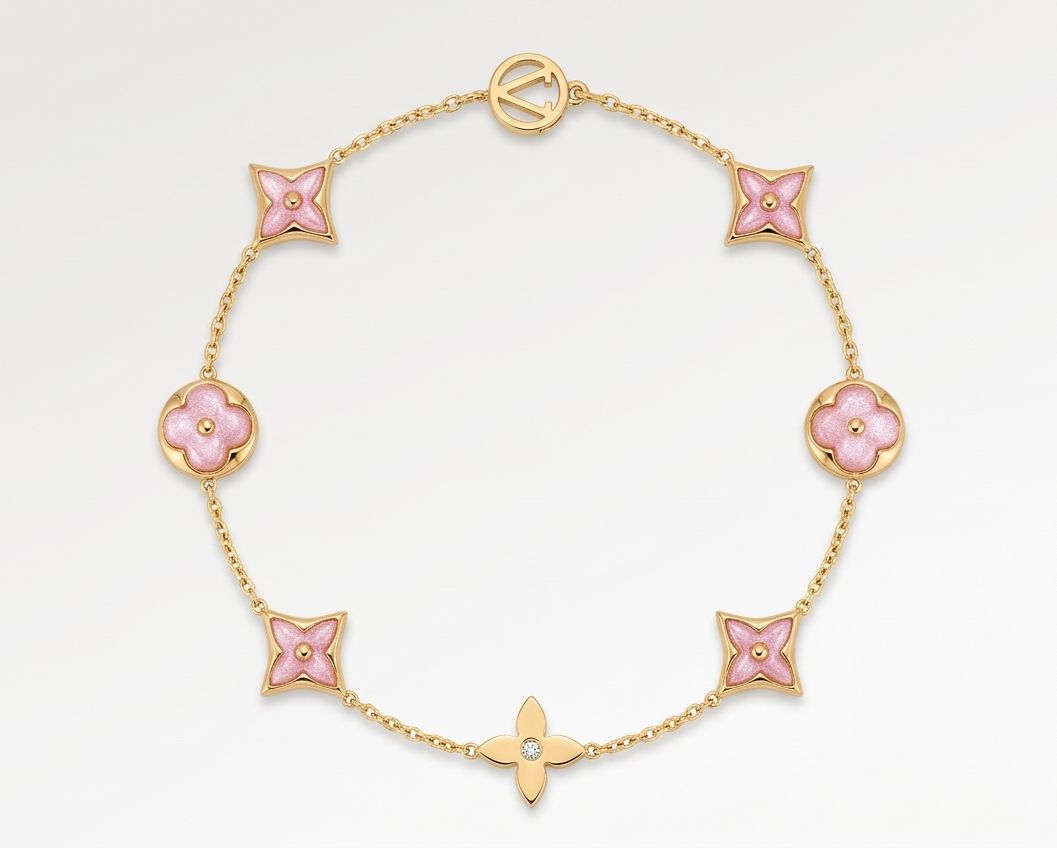 Gold bracelet with pink flower-shaped links on a light gray background