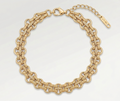 Gold chain bracelet on a light gray background